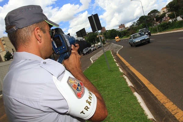Policial militar maneja aparelho em avenida da cidade